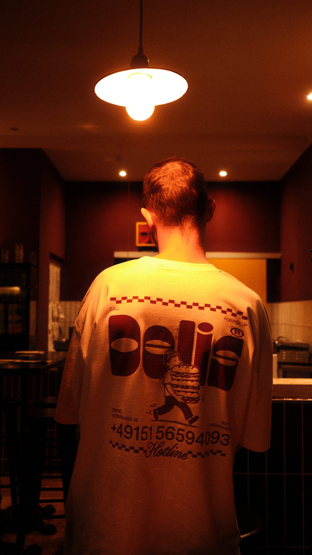 Back print of the DELIS shirt under the pendant lamp