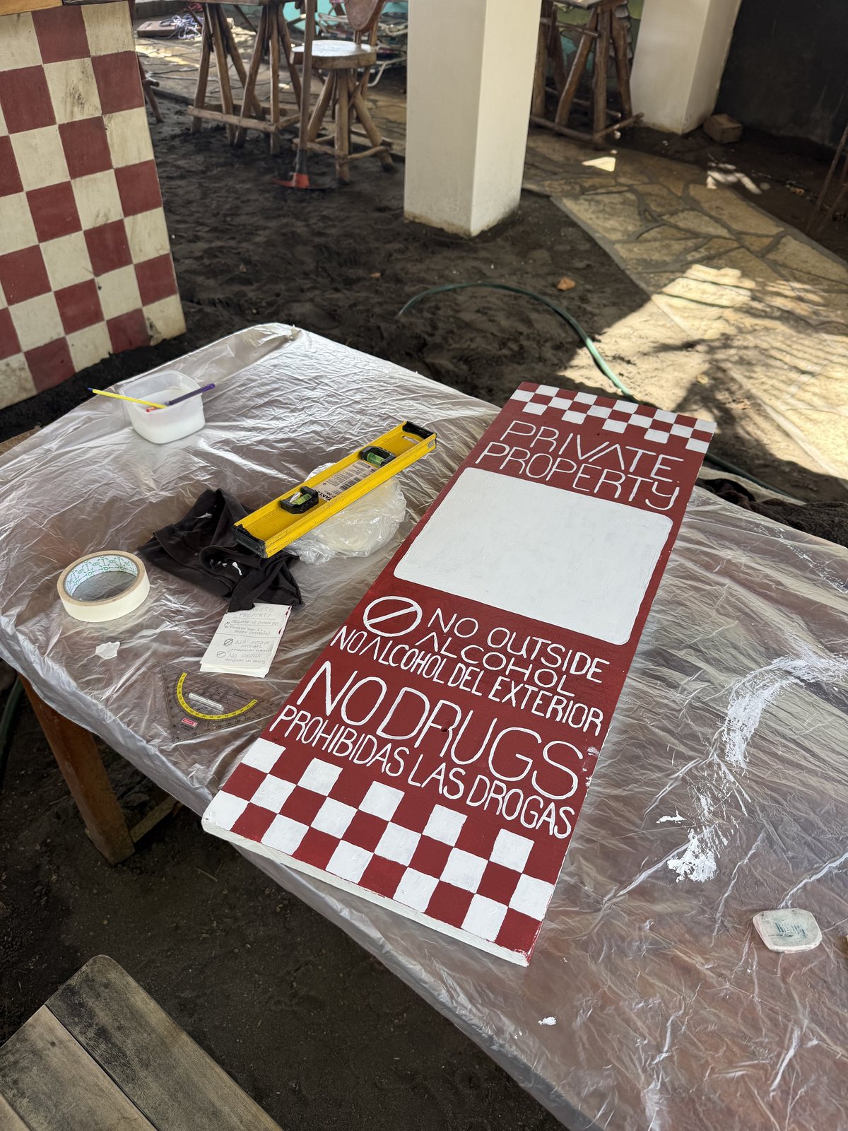House rules painted on a checker board sign: no drugs, no outside drinks