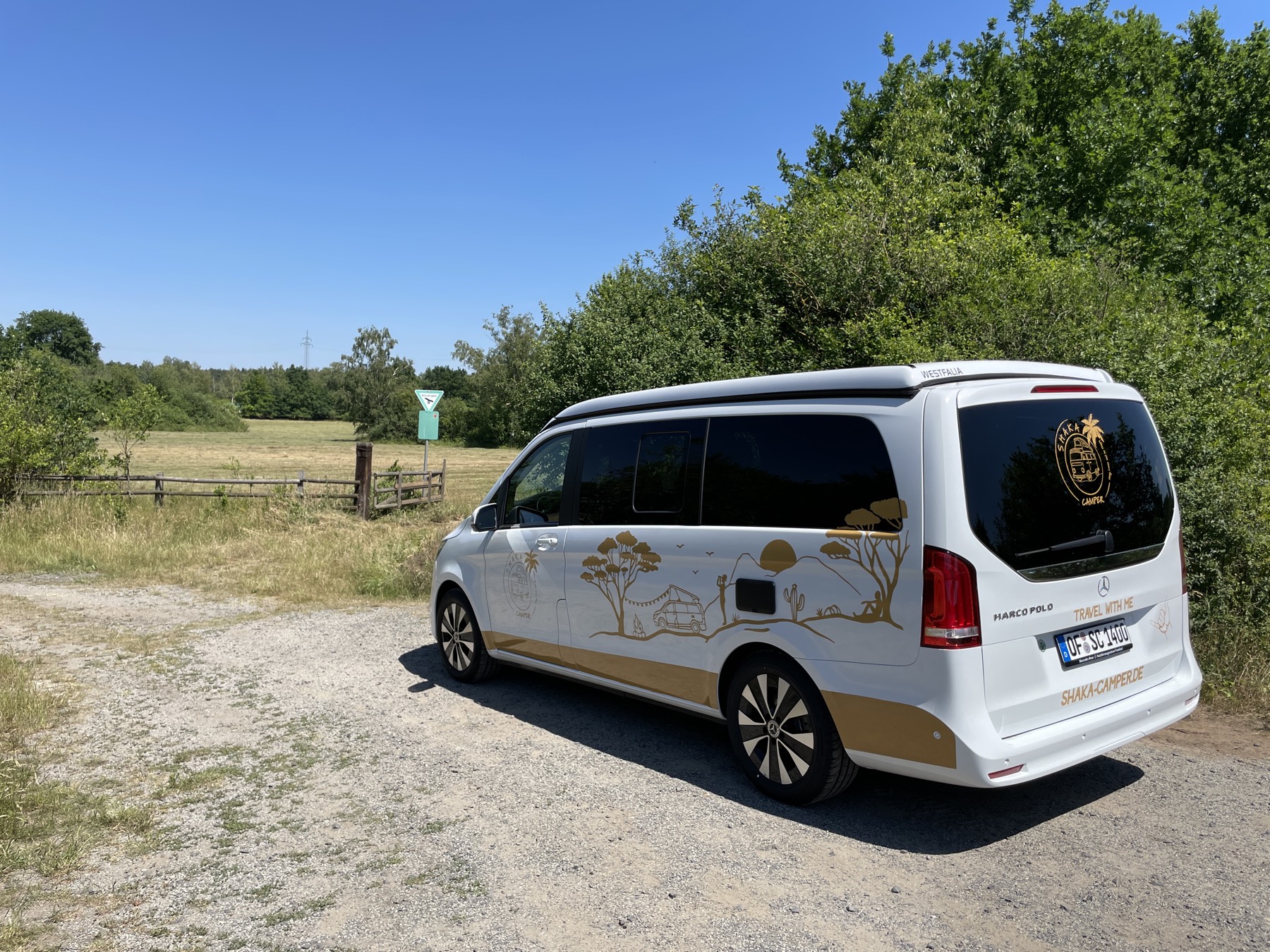 The finished van livery in gold on a white Mercedes Marco Polo, parked by a field